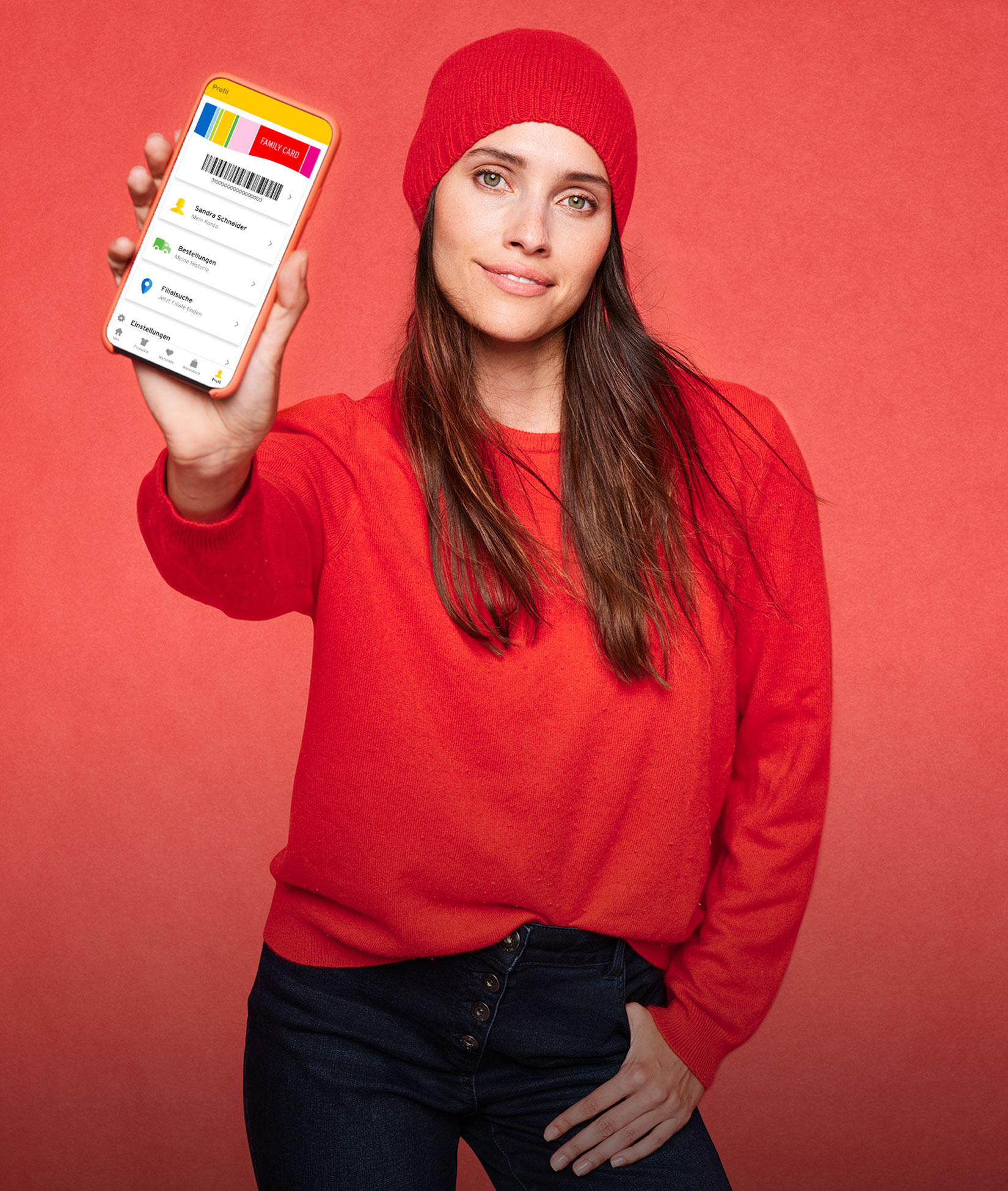 Eine Frau zeigt ihr Handy mit der Ernsting’s family App in die Kamera